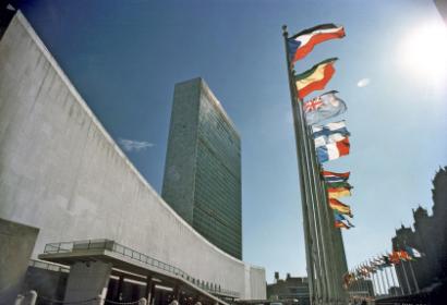 Image of UNHQ with flags under a blue sky. 
